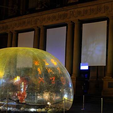 Eine große Bubble steht vor der Frankfurter Börse im Lichtschein.