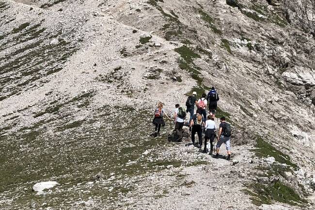 Acht Personen wandern auf einen Berg 