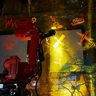Im Fokus steht ein orangener Roboter, der die Piktogramme bestrahlt.
