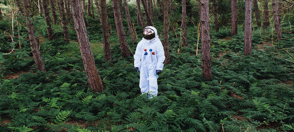 Astronaut steht im Wald