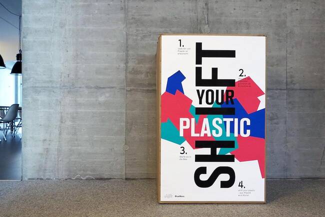 Großer Papierkarton mit Aufschrift „Shift your plastic“ im Shift-Büro in Frankfurt