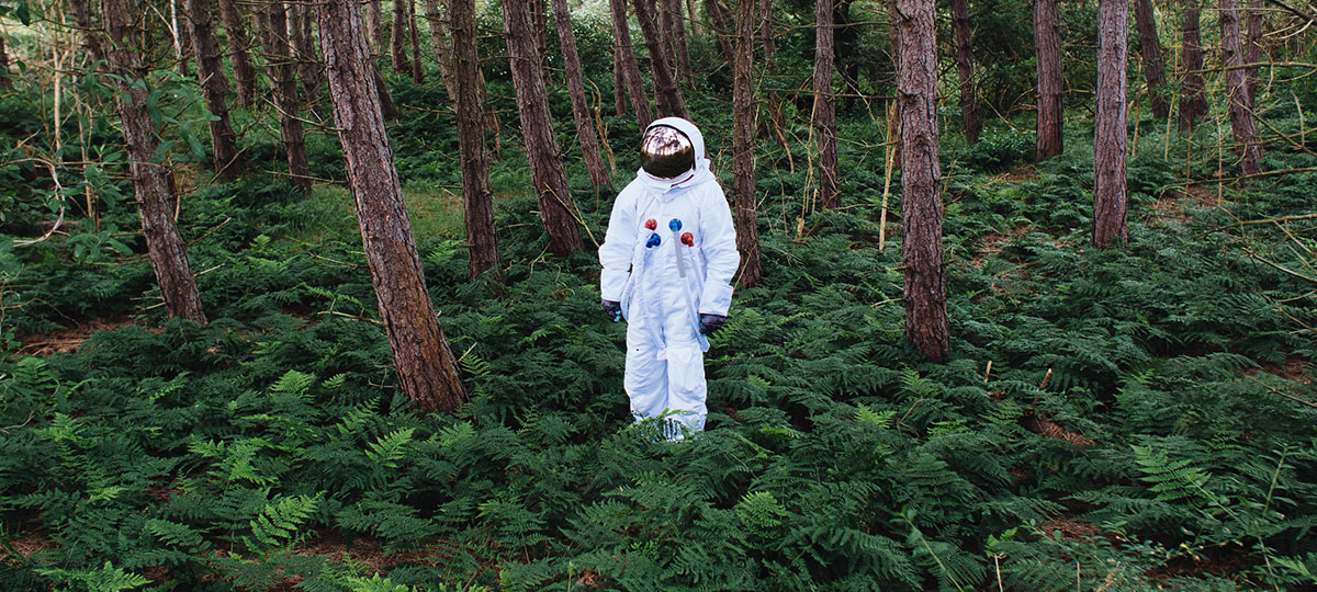 Astronaut steht im Wald